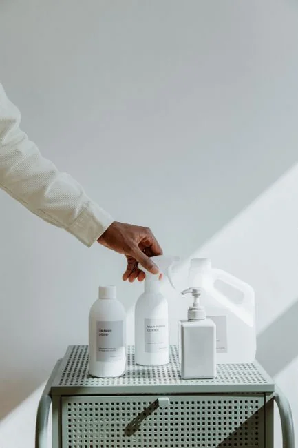 A clean and organized home office desk with a cleaner bottle and sponge, emphasizing simplicity and functionality.